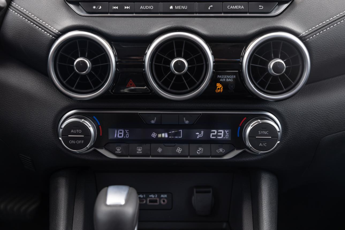 Interior de automóvel com sistema de climatização e painel de controle do ar-condicionado.